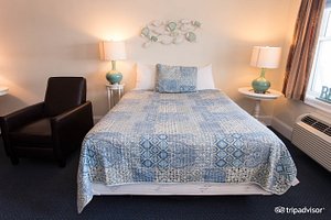 Atlantic Breeze Suites in Hampton, image may contain: Furniture, Bed, Lamp, Chair