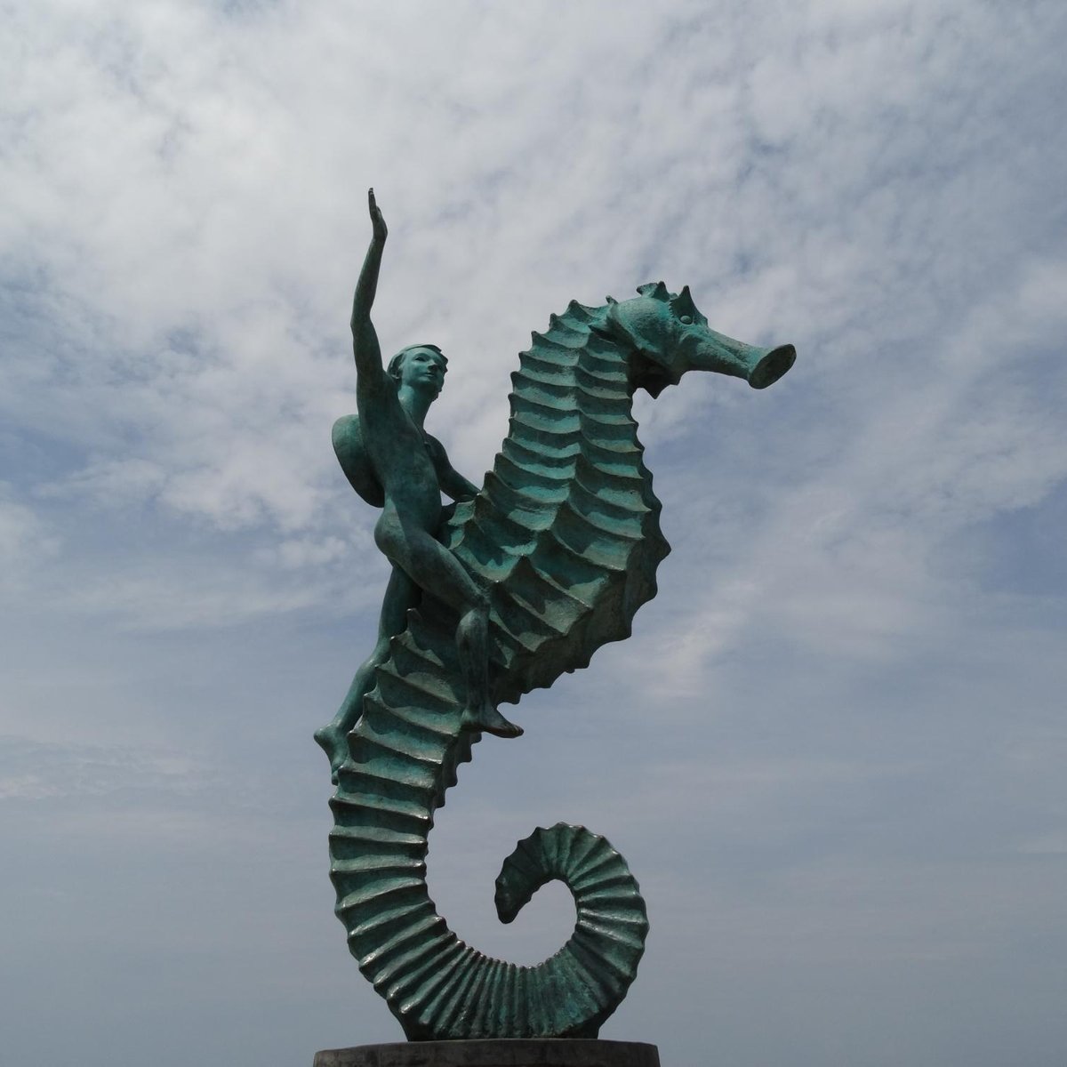 Foto Uma estátua de um cavalo-marinho na frente de um corpo de água –  Imagem de Puerto vallarta