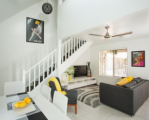 Byron Central Apartments in Byron Bay, image may contain: Staircase, Living Room, Table, Ceiling Fan