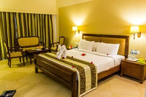 Uday Suites Garden Hotel in Thiruvananthapuram (Trivandrum), image may contain: Hotel, Resort, Chair, Bed