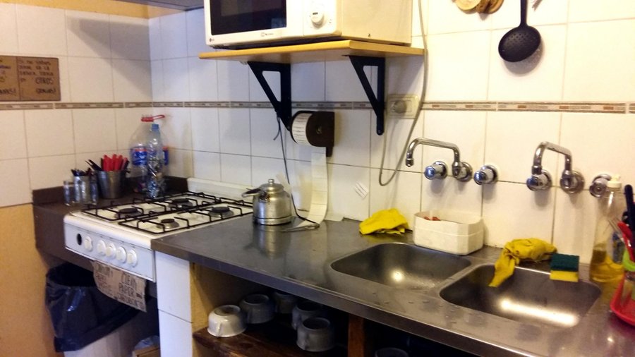 Microondas incluido. Varias tazas y vasos, todo limpio y ordenado.