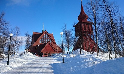 Kyrkan sedd utifrån i vinterskrud och solsken.
