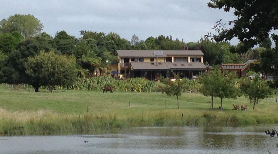 Sicht über den eigenen Teich auf die Lodge mit eigenen Streichelzoo im Vordergrund