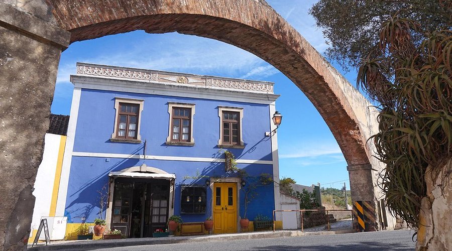 We are the blue building with the yellow door under the aqueduct