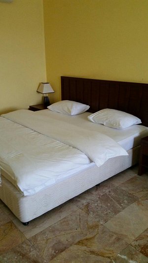 Hamasa Plaza Hotel and Apartments in Buraimi, image may contain: Lamp, Bed, Furniture, Cushion