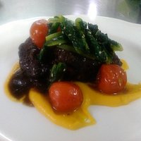 Guancia di maiale brasata, crema di zucca,pomodorini confot e cicoria saltata