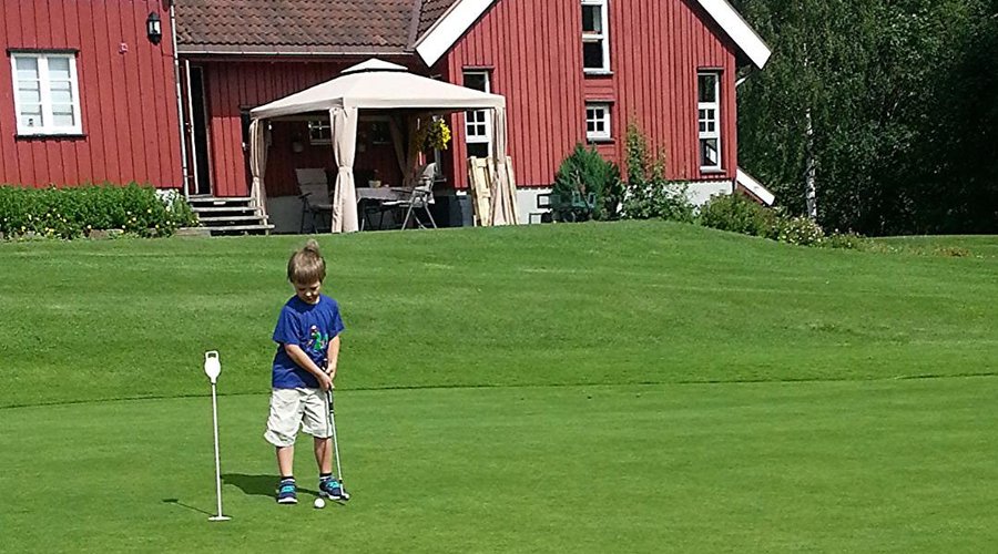 Practicing putting on the greeen behind the club-house