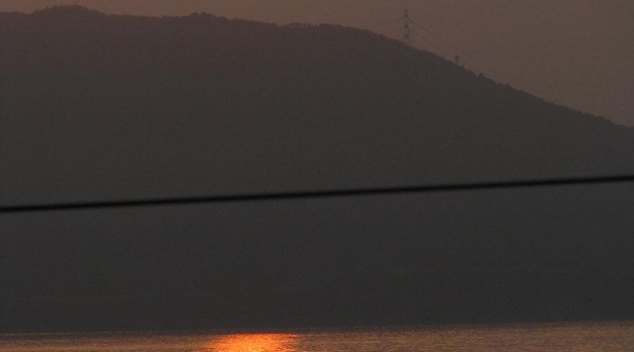 部屋から見る夕陽：低層階では電線が邪魔