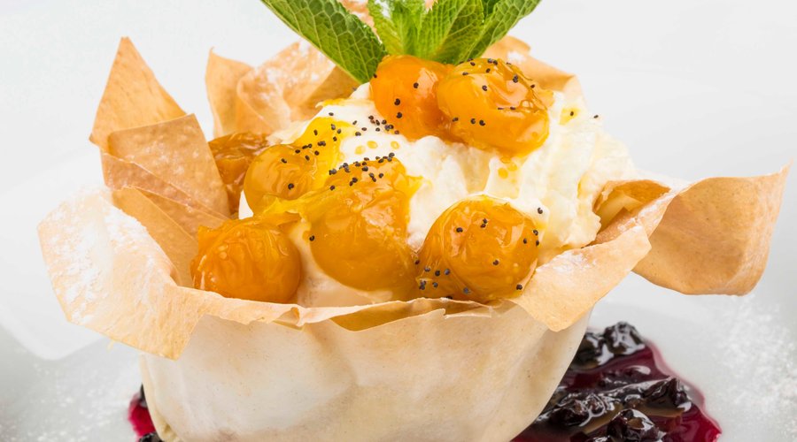 Tulipán de pasta fillo con helado y crema en salsa de mortiño y uchuvas