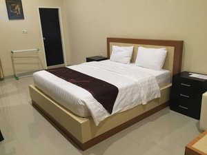 Mitra Utama Hotel in Tolitoli, image may contain: Bed, Furniture, Painting, Chair