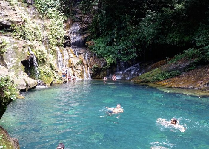 O poço azul, com pequenas caídas de água pela rochas.