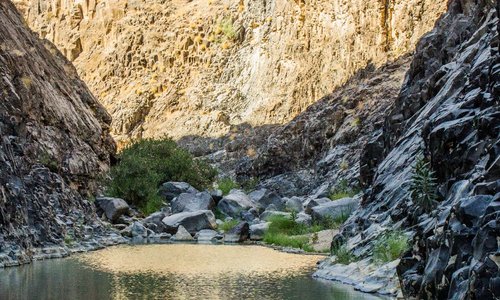Reflection of a mix if colorful rocks on water trail. 