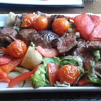 Steak was cut into pieces and arranged with the salad and new potatoes, mushrooms and peppers et