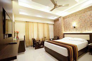 Hotel Deepam in Tiruchirappalli, image may contain: Remote Control, Electronics, Ceiling Fan, Bed