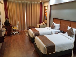 Apollo Dimora Hotel in Thiruvananthapuram (Trivandrum), image may contain: Chair, Furniture, Hotel, Bed