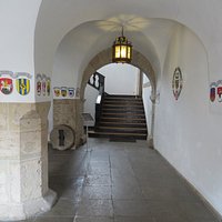 Entrance to city hall with romanesque cross-vaulting and the coats of arms of the region.