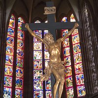 Kreuz mit Kirchenfenstern im Hintergrund