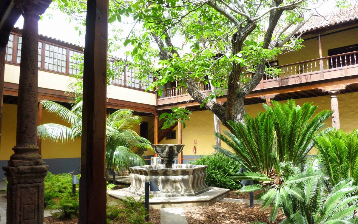 Patio interior de una casa colonial con vegetación y fuente