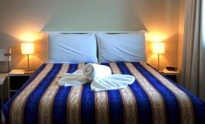 Karuah Motor Inn in Karuah, image may contain: Linen, Furniture, Lamp, Bed