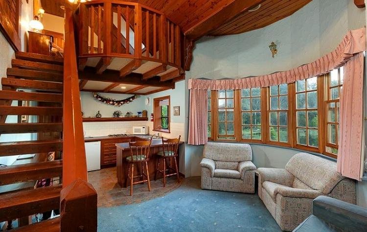 Lounge and kitchen area showing stairway to loft bedroom