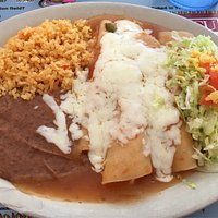 One photo shows some chicken enchiladas topped with cheese, also retried beans, rice and lettuce