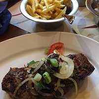 Steak mit Knoblauch, Zwiebeln, Pommes und Salat