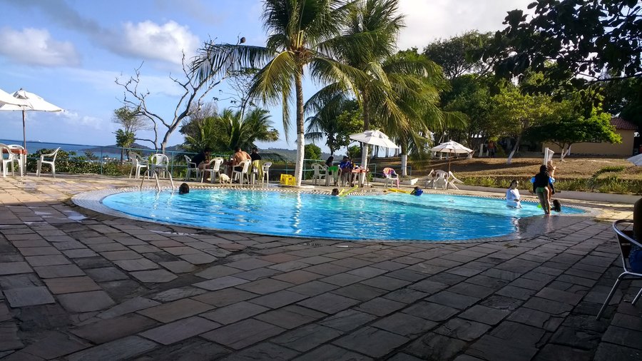Área da piscina com a praia ao fundo