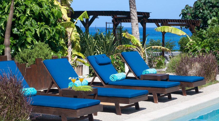 Peaceful pool area with cushioned chaise lounge chairs