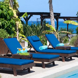 Peaceful pool area with cushioned chaise lounge chairs