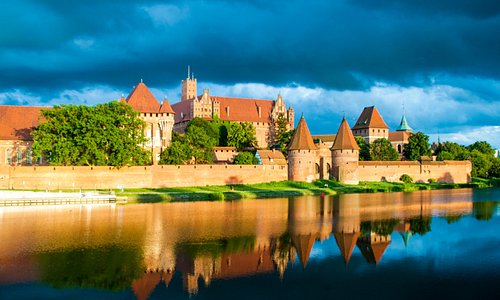 Замок Мариенбург - один из самых больших в мире кирпичных замков и его отражение в протоке Ногат