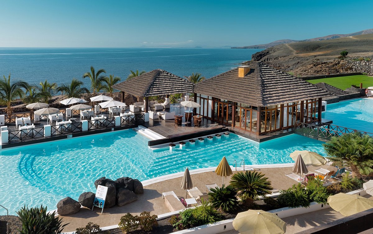 a swimming pool with a gazebo and umbrellas