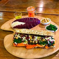 Ciabatta vegana ai cereali con cappuccio, spinaci, ceci, carote, radicchio, semi di chia e olio.