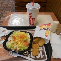 Iced tea, chicken nuggets, and side salad.