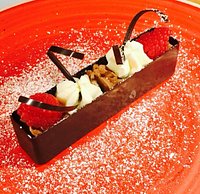 Rettangolo fondente con mousse al cioccolato, panna fresca e lamponi