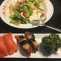 Smoked salmon, unagi & seaweed salad nigiri with green salad remnants in the background--at $6.9