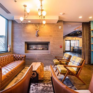 The Oxbow Hotel in Eau Claire, image may contain: Couch, Living Room, Chandelier, Fireplace