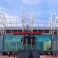 Old Trafford featuring the Trinity statue outside of the East Stand