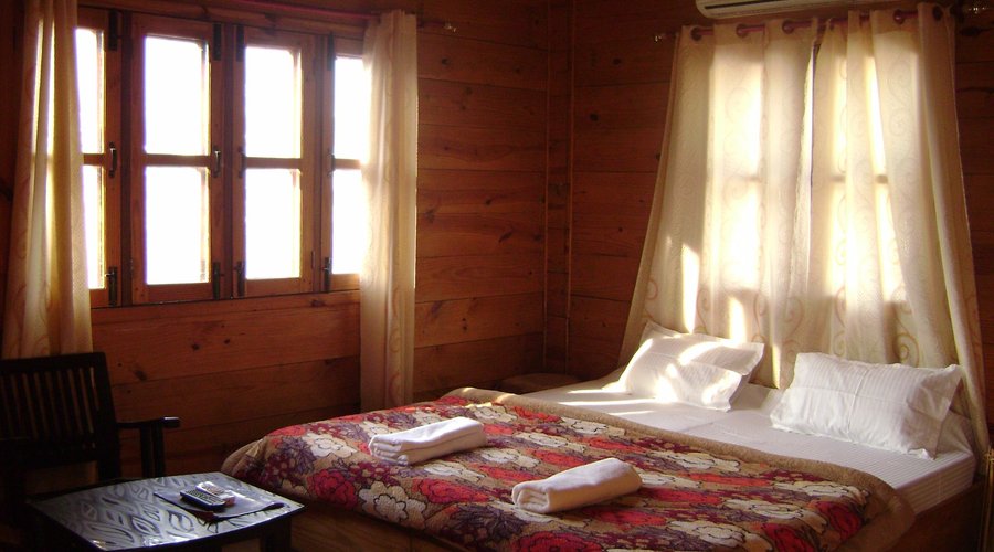 Deluxe Wooden Twin Room with Ganga and Mountain View and an attach balcony and kitchen