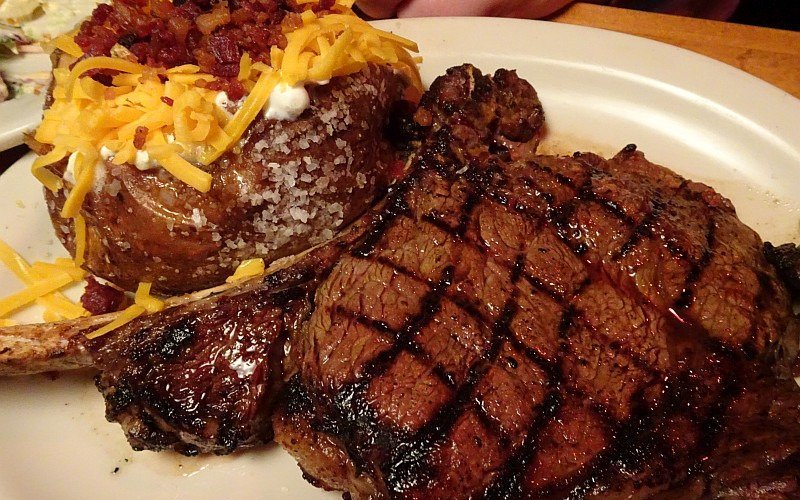 Juicy bone-in Ribeye with loaded baked potato
