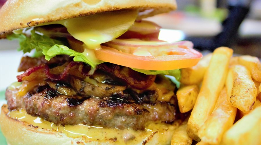 Burger with cheese, bacon & mushrooms all topped with lettuce, tomato & onion. 