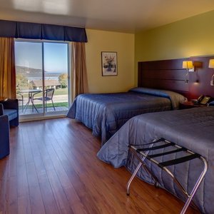 chambre avec deux lits Queens, baignoire, douche, frigo, cafetiere et vue sur le fleuve