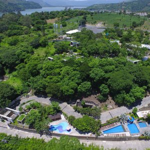 Entre los árboles se ubica Kawilal Hotel.  En la parte inferior las piscinas de Santa Teresita.
