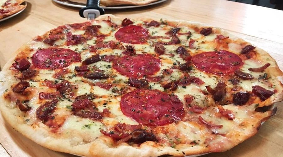 Pizza Lola, datiles, salsa de pimenton asado, chorizo español, tocineta crujiente.