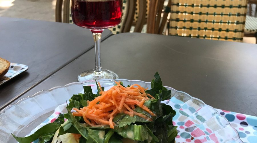 En terasse avec une salade en entrée avec un bon verre de vin bio sans sulfites !