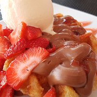 Waffle with chocolate, strawberries and vanilla ice cream