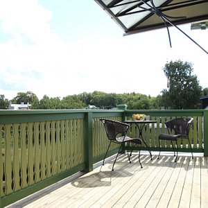 Spacious balcony with coal grill and table set.