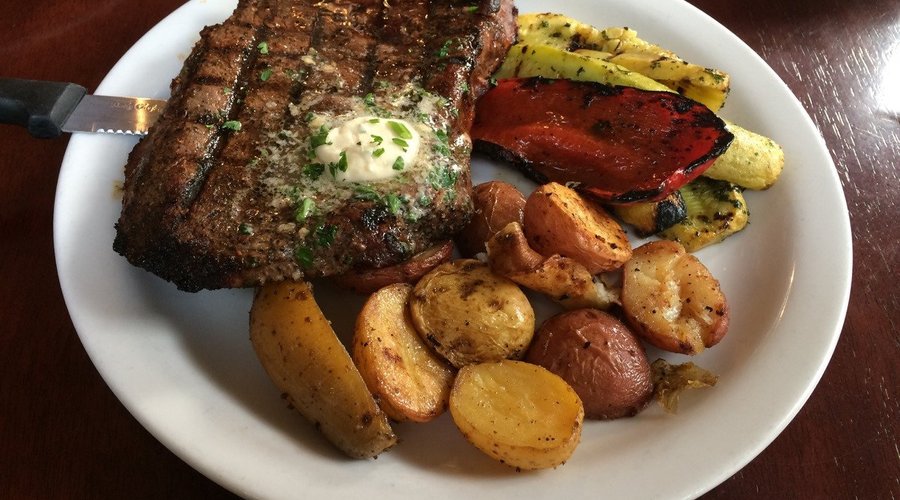 Cowboy Steak with potatoes and mixed grilled vegetables.
