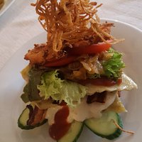Maultaschen burger with cucumbers, tomatoes, lettuce, sauces, bacon, hashbrowns and crispy onion