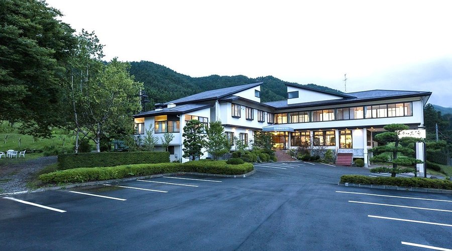 ホテルの外観　広田湾を見下ろす高台に建つ一軒宿。白い外壁に茶色い屋根、周りのお庭が目印です。