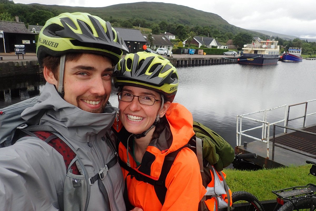 Homme Adulte Et Un Garçon Avec Deux Vélos En Casques Près Du Lac